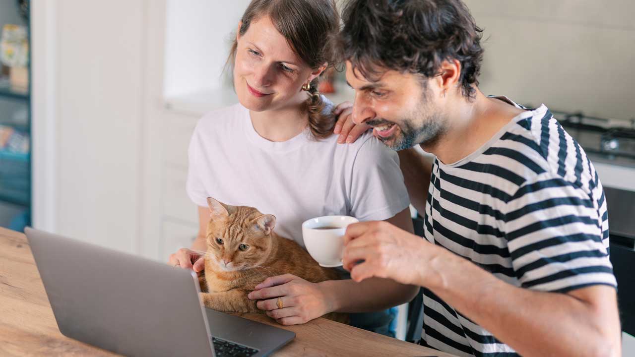 En man som dricker kaffe med en tjej och en katt